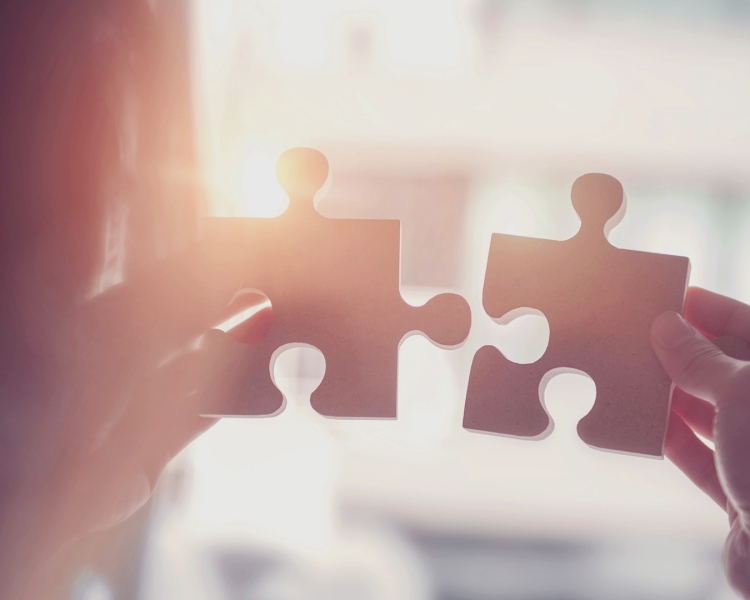 Person puts two puzzle pieces together.