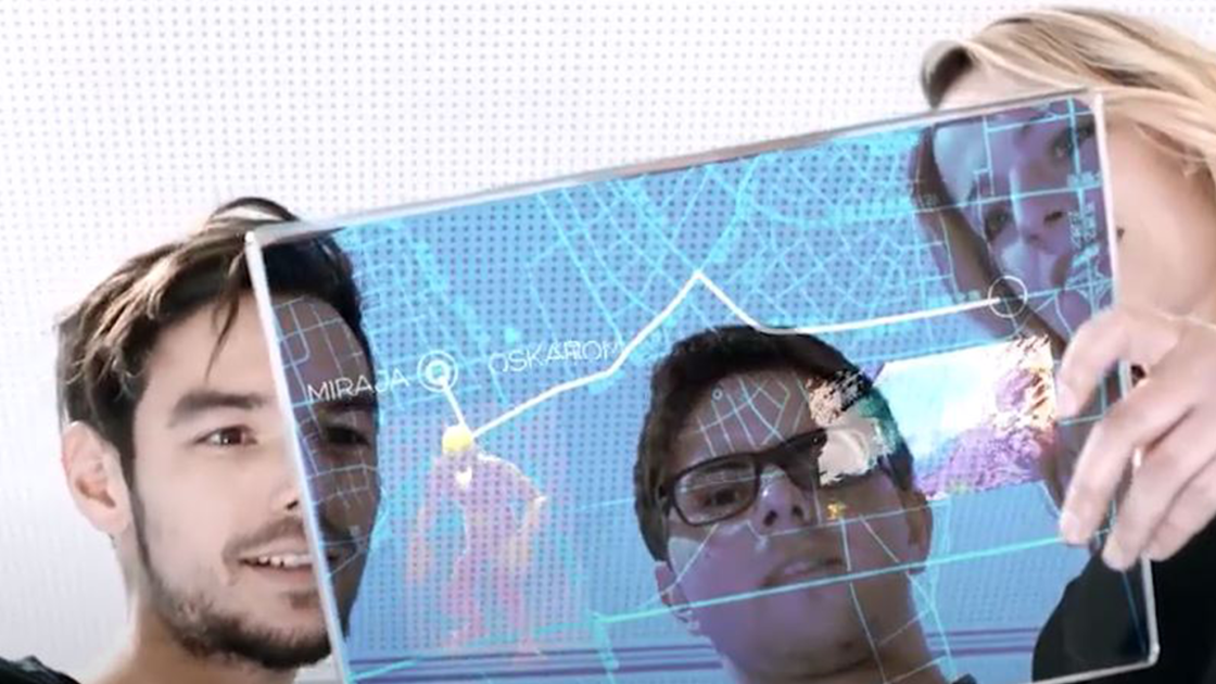 3 Personen sehen sich ein Tablet an