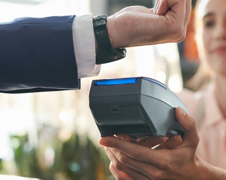 Mann bezahlt mit Smartwatch an Kartenterminal