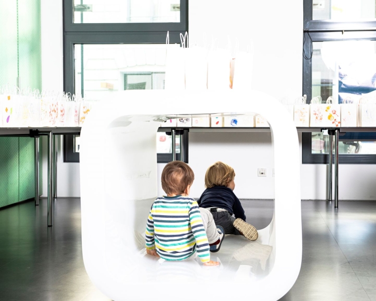 2 Kinder spielen unter einem Tisch