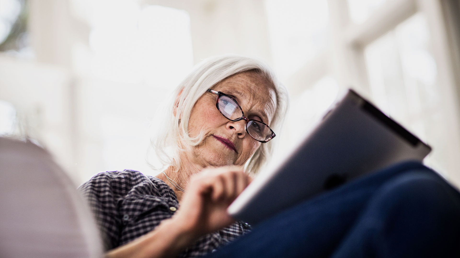 Eine Dame blickt auf ihr Tablet