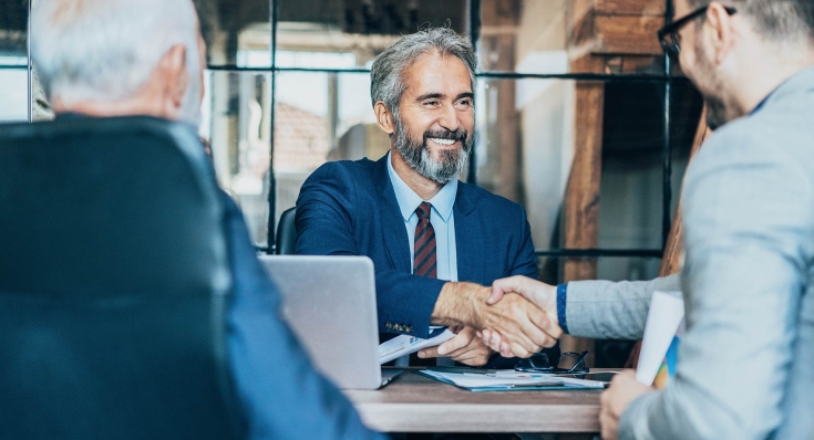 Businessmann schüttelt einer anderen Person die Hand