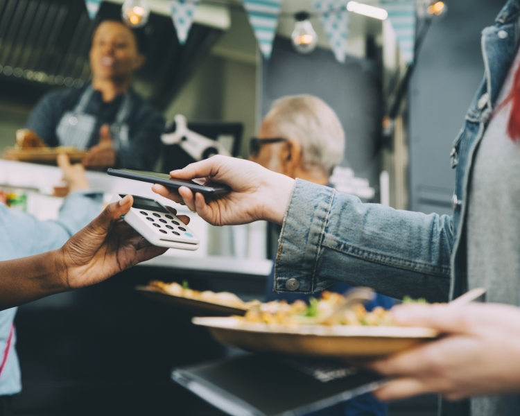 Eine Person bezahlt mit dem Smartphone