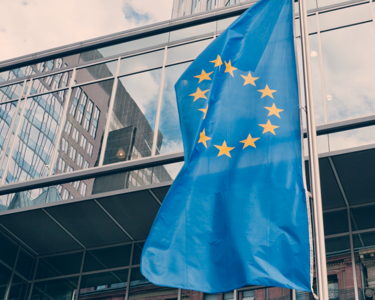 Außenansicht der Europäischen Zentralbank mit der Flagge der EU im Vordergrund