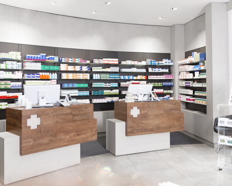 Tara im Verkaufsraum der Apotheke mit Medikamenten in den Regalen
