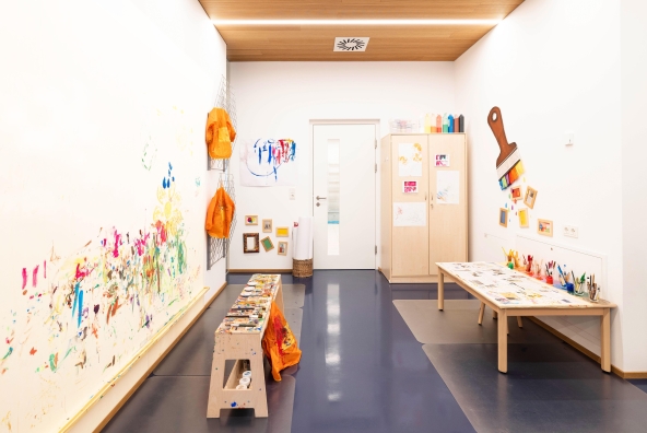 Kreativraum der Kinderbetreuung mit Farben und Tischen zum Malen
