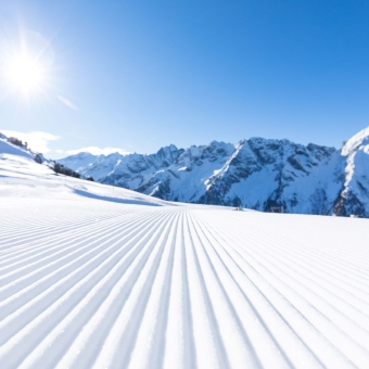 Frisch präparierte Piste, Sonnenaufgang und Berge