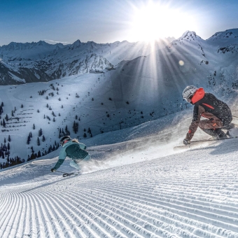 undverspurte Skipiste, 2 Skifahrer, Sonnenaufgang