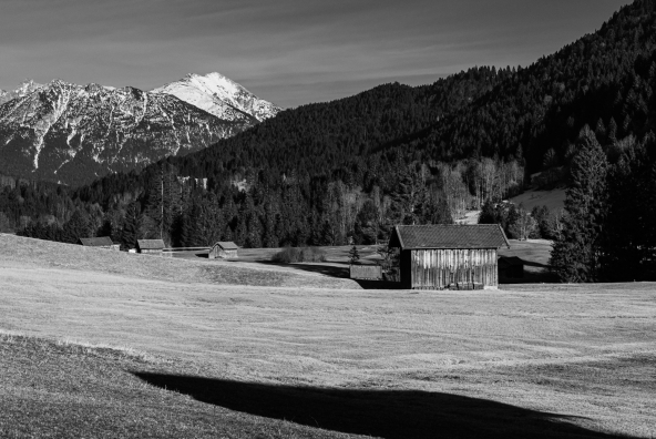 Landschaft im Sommer mit Scheune und Berglandschaft im Hintergrund