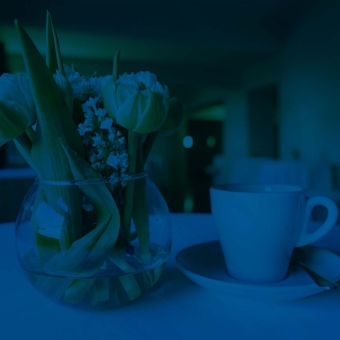 Blumenvase mit einer Kaffeetasse