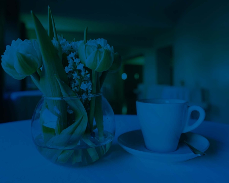 Blumenvase mit einer Kaffeetasse