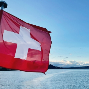 Schweizer Flagge mit einem See im Hintergrund