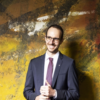 Ein Mann trägt einem Anzug und eine Brille