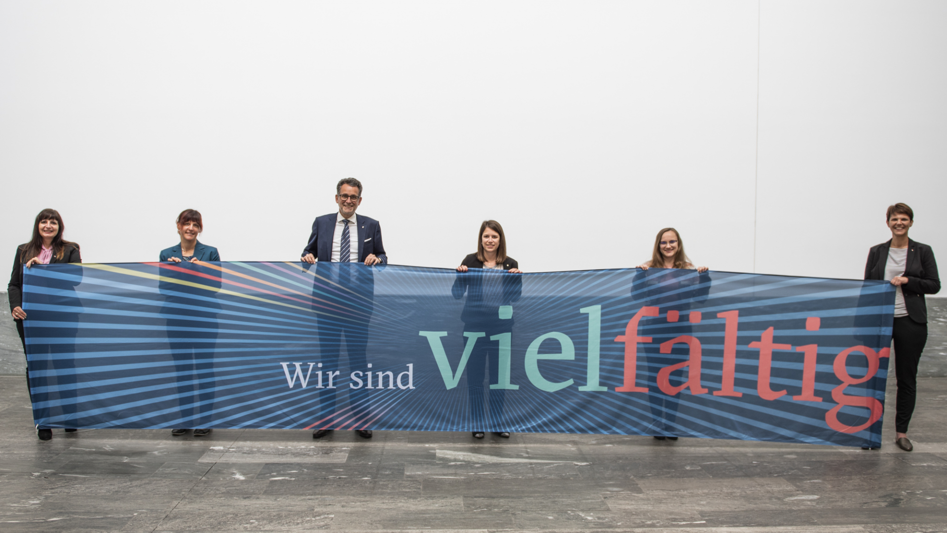 6 Mitarbeiter*innen mit einem BTV vielfältig Banner