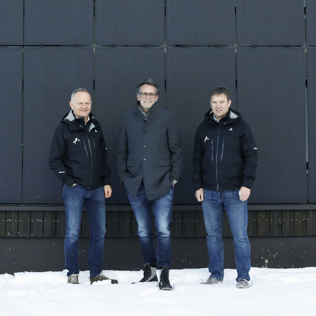 3 Personen stehen vor einer schwarzen Wand