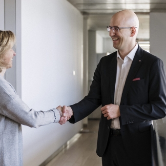 Eine Frau und ein Mann geben sich lächelnd die Hand.