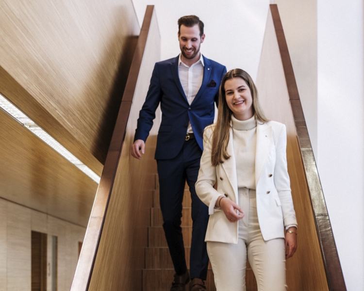 Zwei Personen gehen lachend eine Treppe hinunter.