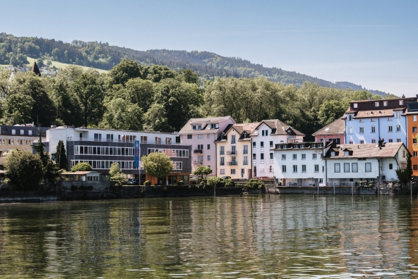 Ein See mit verschiedenste Häuserfassaden im Hintergrund.