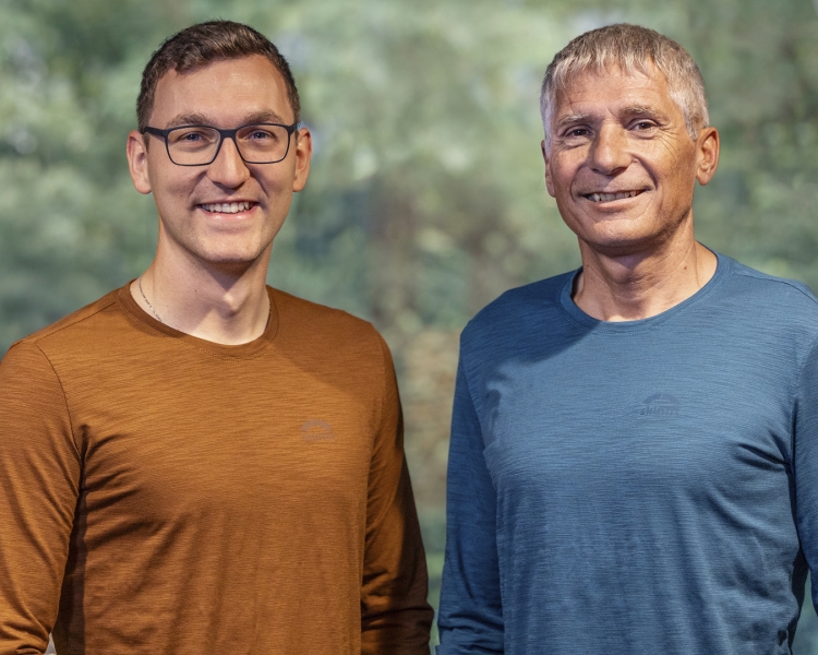 Zwei Männer, Gründer Werner Battisti und Geschäftsführer Daniel Frei von Skinfit, vor grauem Hintergrund