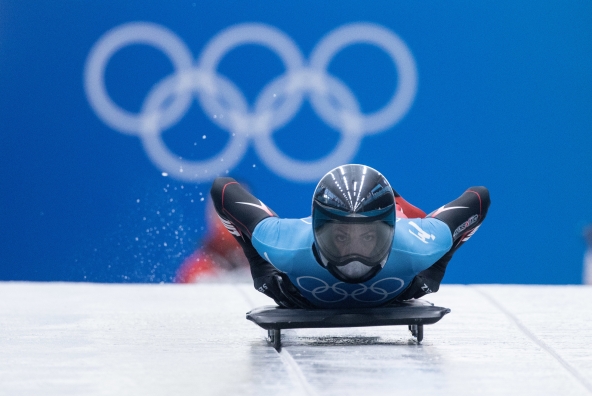 Die Olympiateilnehmerin Janine Flock fährt auf einem Skeleton (Rennschlitten) den Eiskanal hinunter.
