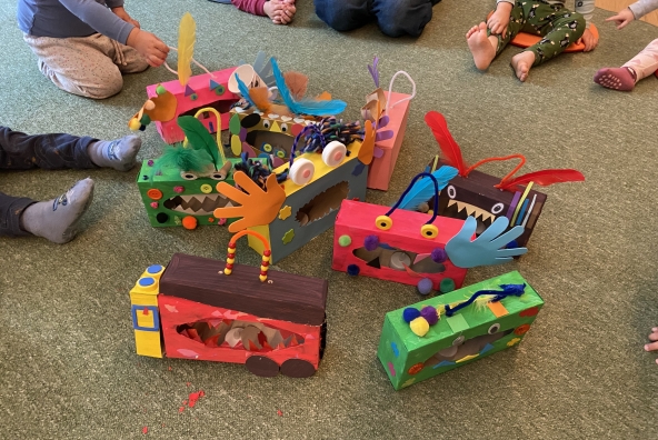 Kinder sehen sich ihre selbst gebastelten Kunstwerke an