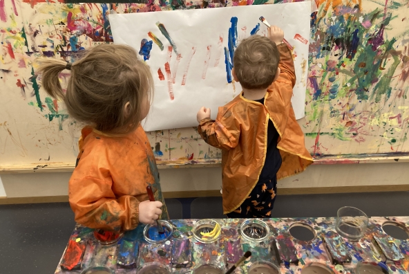 2 Kinder malen etwas an die Wand