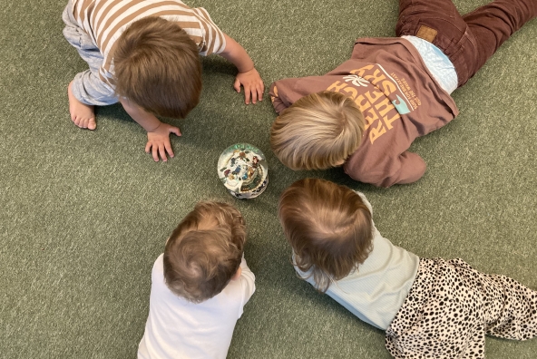4 Kinder sehen sich eine Glaskugel an