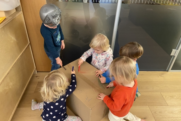 5 Kinder malen auf einer Kartonbox