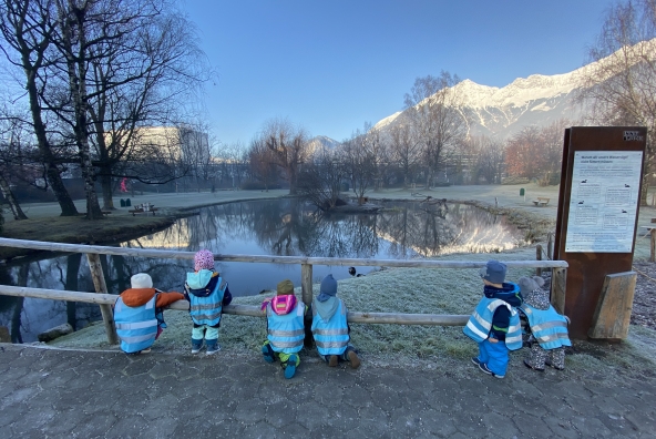6 Kinder schauen auf einen Teich herab