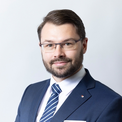 Benjamin Telser im blauen Anzug mit weißem Hemd und blau-weiß gestreifter Krawatte