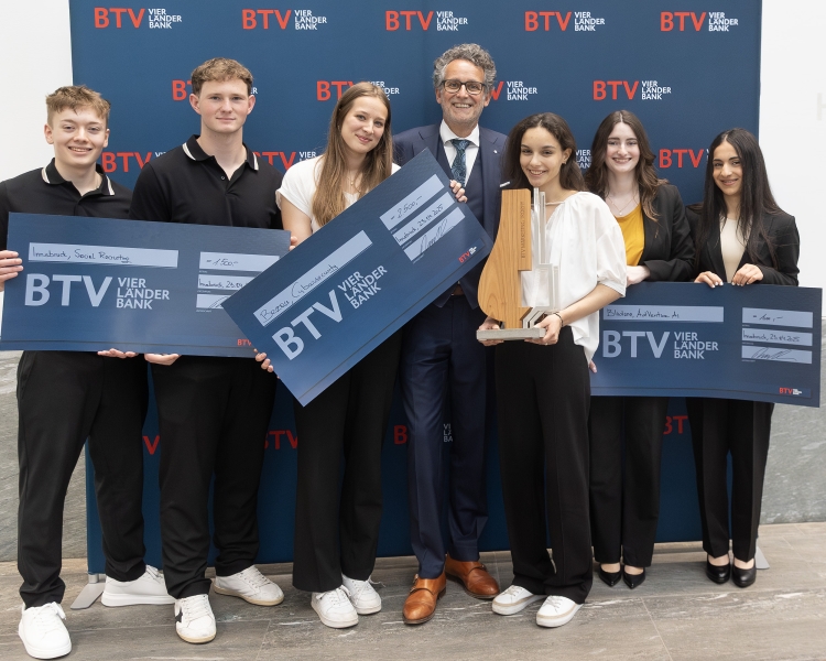 7 Personen halten einen Preis in der Hand