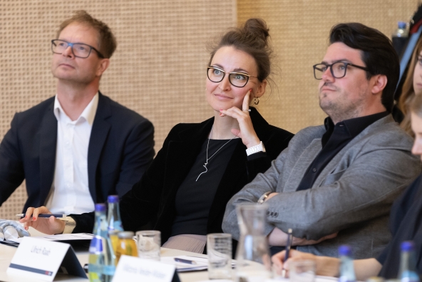Drei Personen sitzen an einem Tisch