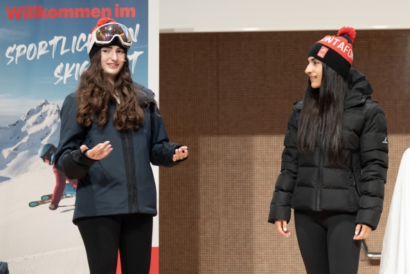 Zwei Frauen stehen auf einer Bühne mit Winterbekleidung