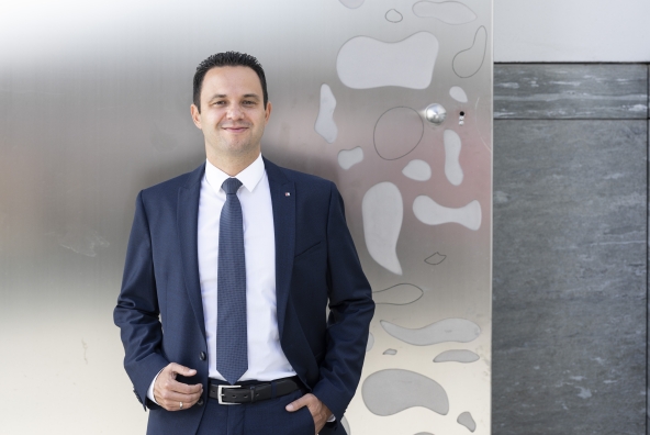 Ein Mann steht vor einem Gebäude und trägt einen blauen Anzug