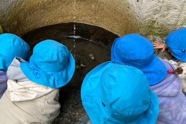 Kinder spielen an einem Brunnen