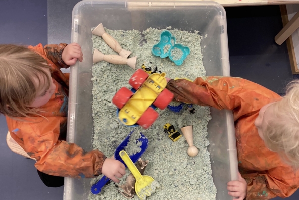 Zwei Kinder spielen mit Sand und Spielzeug