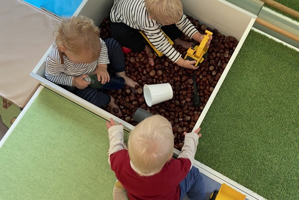 Drei Kinder spielen in einem Sandkasten