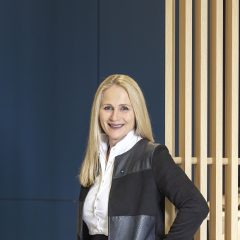 Eine Frau steht vor einer blauen Wand in einer Bankfiliale