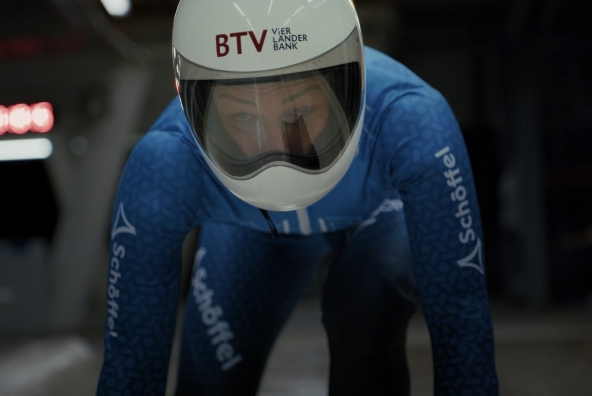 Eine Frau fährt mit einem Skeleton durch einen Eiskanal