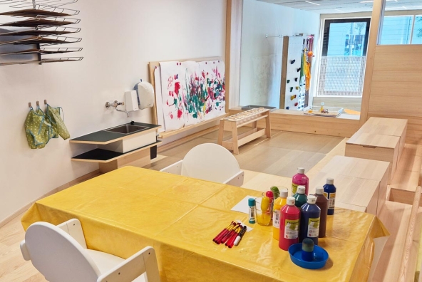 Kreativraum der Kinderbetreuung mit Farben und Tischen zum Malen im MUKKI Dornbirn