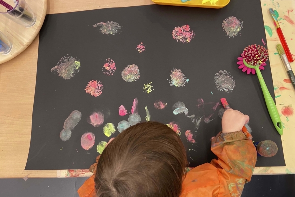 Ein Kind malt mit bunten Farben