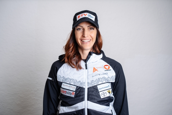 Janine Flock mit weiß-dunkelblauer Jacke und dunkelblauer Schildkappe