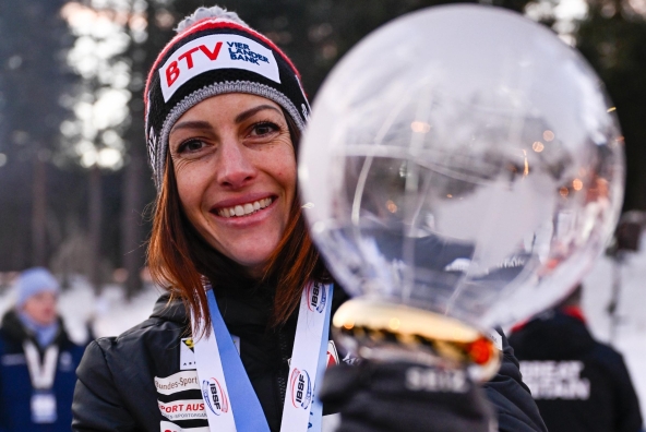 Skeletonfahrerin Jeannine Flock präsentiert ihren Pokal als frisch gekürte Gesamtweltcupsiegerin 24/25