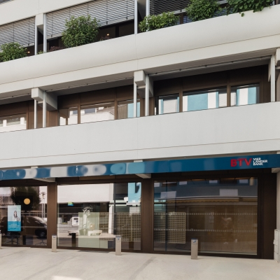 Außenansicht der BTV Bank Filiale in Landeck in der Malserstraße 34 mit Bankomat neben der Eingangstür.
