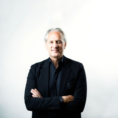 Porträtfoto von Mag. Martin Ohneberg, CEO der HENN Connector Group. Er blickt freundlich in die Kamera und trägt einen dunklen Anzug mit Hemd. Der Hintergrund ist neutral gehalten.