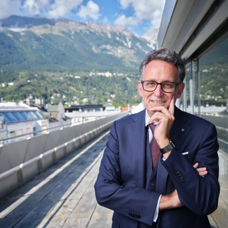 BTV-Vorstand Gerhard Burtscher steht auf der Terrasse der BTV Stadtforum Filiale und blickt in die Kamera.