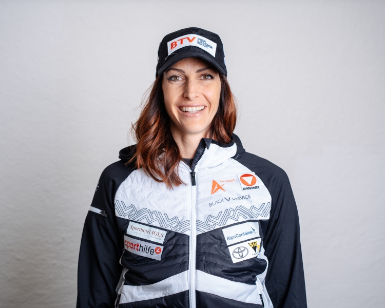 Skeletonpilotin Janine Flock posiert zum Kick‑off des Saisonsstarts 2025 und trägt dabei Sportkleidung ihrer Sponsoren.
