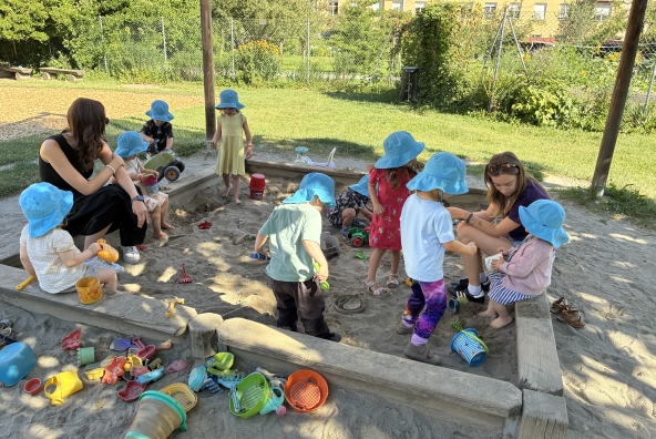 Kinder der MUKKI‑Kinderkrippe spielen gemeinsam in einem Sandkasten.