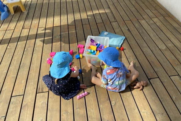 Kinder der MUKKI‑Kinderkrippe spielen gemeinsam mit bunten Legosteinen und bauen kleine Konstruktionen.