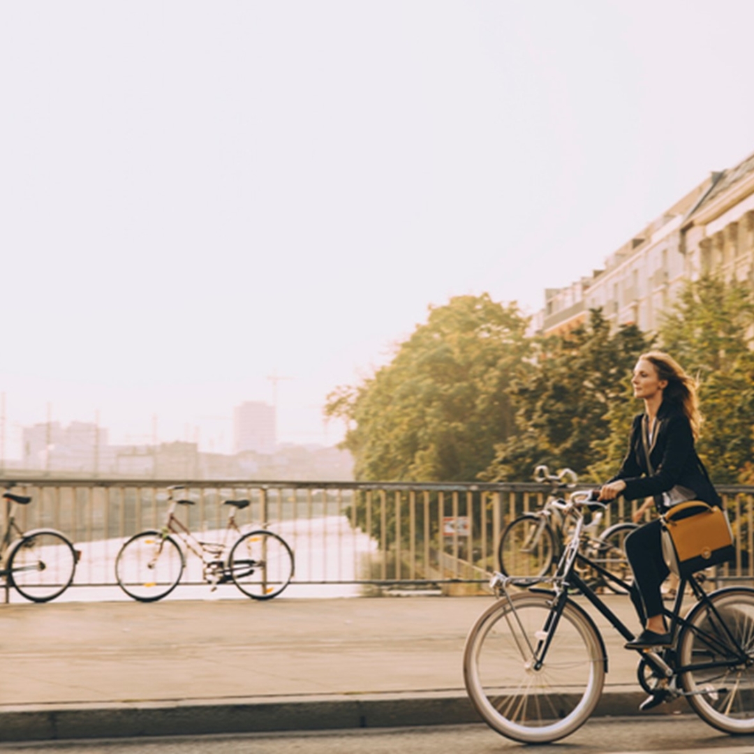 Eine Frau fährt mit dem Fahrrad über eine Brücke.
